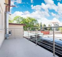 Ein Balkon in Dunajská Streda mit Blick auf die Umgebung von Gebäuden und einem Park.