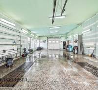 Innenwaschhalle mit nassem Boden und Leuchtstoffröhren an der Decke.