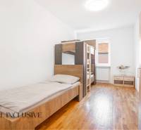 Das Innere eines Schlafzimmers in einem Gebäude mit Betten und einem Boden in Holzoptik.