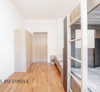 Ein Interieur mit einem Etagenbett, Schränken und einem Boden mit Holzdekor.