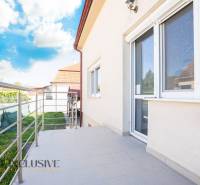 Ein Gebäude in Dunajská Streda mit Terrasse und Geländer, Himmel mit Wolken.