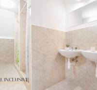 Badezimmer mit zwei Waschbecken und Dusche, dekorative Fliesen und Spiegel im Gebäude.