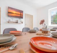 Ein Speisesaal in einem Gebäude mit einem dekorativen Tisch, bunten Tellern und einem Fernseher an der Wand.