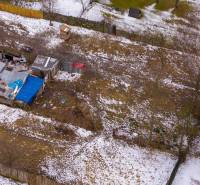 Gärten in Nálepkovo mit vereistem Schnee, älteren Unterständen und Zäunen im Winter.