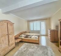 Schlafzimmer in einem Einfamilienhaus mit Holzmöbeln und einem Boden mit Holzdekor.