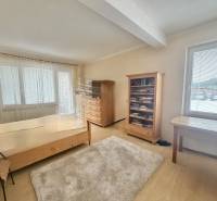 Zimmer mit Bett, Bücherregal und Tisch in einem Einfamilienhaus in der Straße Čadečka.