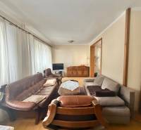 Wohnzimmer in einem Einfamilienhaus mit Holzboden, Sofa und Vorhängen.