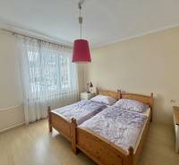 Schlafzimmer mit Doppelbett und Kronleuchter in einem Einfamilienhaus mit Holzboden.