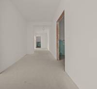 Ein Flur im Bau in einer 4-Zimmer-Wohnung mit unverputzten Durchgängen und neutralen Wänden.