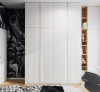 Weißer Einbauschrank mit dekorativer schwarzer Tapete und Bodenbelag in Holzoptik in einer 4-Zimmer-Wohnung.
