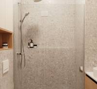 Badezimmer einer 4-Zimmer-Wohnung mit moderner Duschkabine und Stauraum.