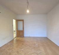 Ein Zimmer in einer 2-Zimmer-Wohnung mit Holzboden und offenen Türen.