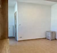 Weißes Interieur einer Einzimmerwohnung mit Fliesen und Holzelementen.