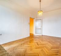 Ein leerer Raum mit einem Kronleuchter, einer Tür und einem Boden mit Holzdekor, eine 2-Zimmer-Wohnung.