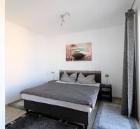 Helles Schlafzimmer in einer 2-Zimmer-Wohnung mit bequemem Bett und Teppich.