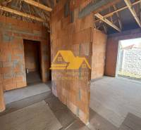 Ein im Bau befindliches Einfamilienhaus mit Blick auf unverputzte Wände und einem hölzernen Dachstuhl.