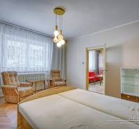 Ein Schlafzimmer in einem Einfamilienhaus mit hellen Holzmöbeln und bequemen Sesseln.