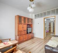 Wohnzimmer in einem Einfamilienhaus mit Holzmöbeln und bequemen Sitzgelegenheiten.