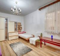 Ein Einfamilienhaus mit Holzboden, Kronleuchtern und Möbeln, ein Zimmer mit Tageslicht.