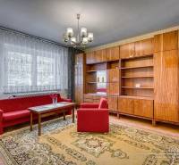Wohnzimmer in einem Einfamilienhaus mit roten Sofas, Kronleuchter und Holzwand-Einheit.