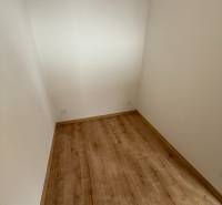 Ein kleiner Raum in einer Einzimmerwohnung mit einem Boden in Holzoptik.