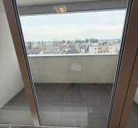 Blick vom Balkon einer Einzimmerwohnung in Trebišov, Hodvábna, durch große Balkontüren.