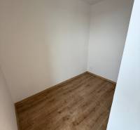 Ein leerer Raum in einer Einzimmerwohnung mit Holzboden und weißen Wänden.