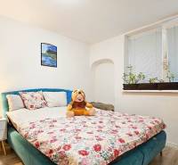 Ein Schlafzimmer in einem Einfamilienhaus mit einem Blumenmuster auf dem Bett und Dekorationen.