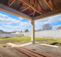 Bauablauf eines Einfamilienhauses in Pavlice mit Holzdachkonstruktion und gestaltetem Hof.