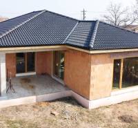 Ein Einfamilienhaus in Pavlice mit schwarzem Dach und einer Terrasse im Garten.