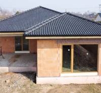 Einfamilienhaus in Pavlice im Bau, Ziegelfassade, dunkles Dach, große Fenster.