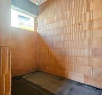 Leerer Raum in einem im Bau befindlichen Einfamilienhaus mit Ziegelwänden.