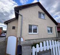 Ein Einfamilienhaus in Zbehy mit einem Schrägdach, einem Zaun und einer Zufahrtsstraße.