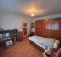 Schlafzimmer in einem Einfamilienhaus mit Bett, Schrank und Boden mit Holzdekor.