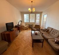 Wohnzimmer in einer 3-Zimmer-Wohnung mit Sofa, Fernseher und Holzboden.