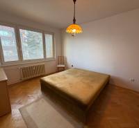 Schlafzimmer in einer 3-Zimmer-Wohnung mit Fenster, Bett und Boden in Holzoptik.