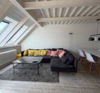 Wohnzimmer mit Holzboden, Sofa und Esstisch in einer 4-Zimmer-Wohnung.