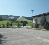 Skihang in Makov mit angrenzendem Gebäude und umliegendem Grün.