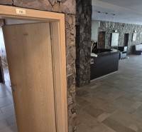 Steinwände und Holztüren, die in das Büro in einer Einzimmerwohnung führen.