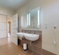 Ein Badezimmer in einem Einfamilienhaus mit zwei Waschbecken, einer Duschkabine und einem großen Spiegel.