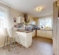 Küche in einem Einfamilienhaus mit Barhockern und einem Boden in Holzoptik.