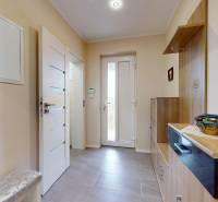 Eingangsbereich eines Einfamilienhauses mit Fliesen, dekorativen Bildern und Stauraum.