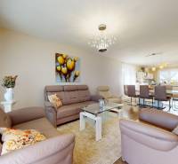 Wohnzimmer in einem Einfamilienhaus mit Ledersofas und Glastisch.