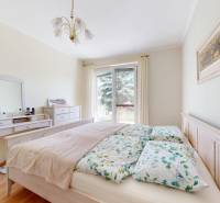 Schlafzimmer in einem Einfamilienhaus mit Bett, Schminktisch und Boden mit Holzdekor.