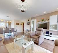 Wohnzimmer eines Einfamilienhauses mit Ledersitzgarnitur und Holzbodenoptik.