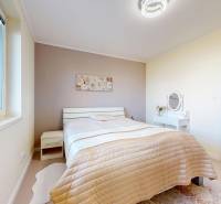 Helles Schlafzimmer in einem Einfamilienhaus mit Bett und Tisch.