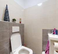 Toilette mit Fliesen und Waschbecken in einem Einfamilienhaus.