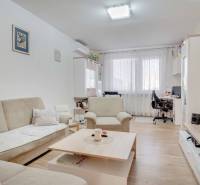 Wohnzimmer in einer 3-Zimmer-Wohnung mit Holzboden und bequemen Sitzgelegenheiten.