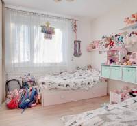 Kinderzimmer in einer 3-Zimmer-Wohnung mit Spielzeug und Bett, Boden mit Holzdekor.