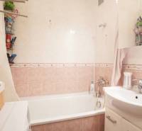 Badezimmer mit Badewanne und Waschbecken in einer 3-Zimmer-Wohnung, Fliesen in sanften Farbtönen.